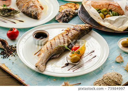Gourmet grilled sea bass fish on the served table Gourmet grilled sea bass fish on the served table 73984997