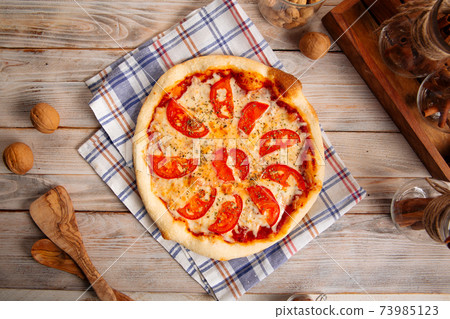 Margherita pizza with tomatoes on the wooden table 73985123