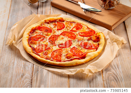 Margherita pizza with tomatoes on the wooden table 73985145