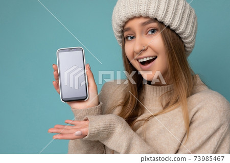 Closeup portrait Photo of surprised happy beautiful young woman wearing stylish beige sweater and 73985467