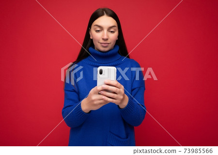 Beautiful young woman wearing casual clothes standing isolated over background surfing on the Beautiful young woman wearing casual clothes standing isolated over background surfing on the 73985566