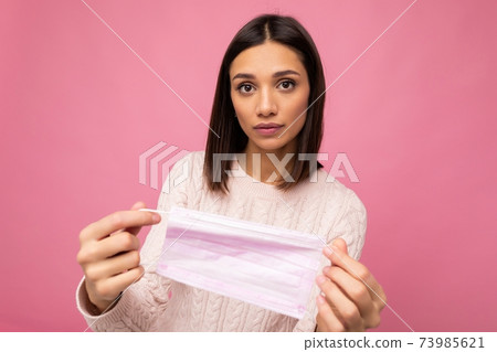 Brunette woman holding an anti virus protection mask to prevent others from corona COVID-19 and SARS 73985621