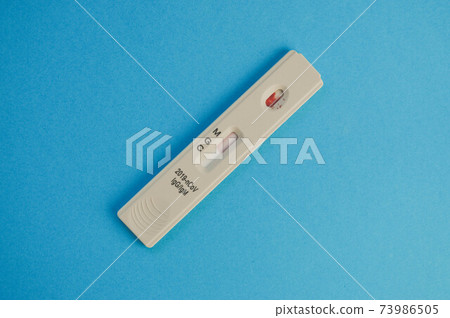 coronavirus test lies on a blue background. a drop of venous blood on the test strip. medical laboratory, express diagnostics of coronavirus 73986505