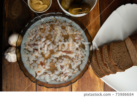 Jellied meat on a brown wooden background.Homemade jelly meat with mustard and horseradish on the table. Holodets Jellied meat on a brown wooden background.Homemade jelly meat with mustard and horseradish on the table. Holodets 73986684