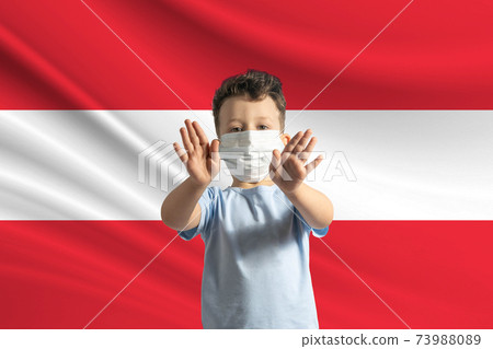 Little white boy in a protective mask on the background of the flag of Austria. Makes a stop sign with his hands, stay at home Austria Little white boy in a protective mask on the background of the flag of Austria. Makes a stop sign with his hands, stay at home Austria 73988089