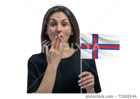 Happy young white woman holding flag of Faroe Islands and covers her mouth with her hand isolated on a white background Happy young white woman holding flag of Faroe Islands and covers her mouth with her hand isolated on a white background 73988244