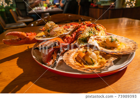 Tasty grilled lobster and scallops in luxury seafood restaurant Tasty grilled lobster and scallops in luxury seafood restaurant 73989393