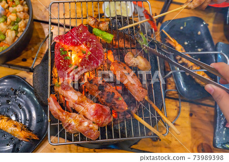 Top view photo of delicious barbecue meats on charcoal stove Top view photo of delicious barbecue meats on charcoal stove 73989398