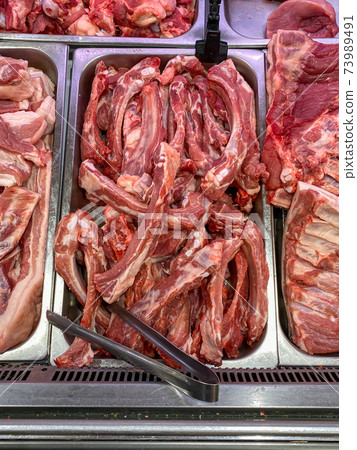 Vertical photo of raw pork meat for sale at butcher stall 73989491