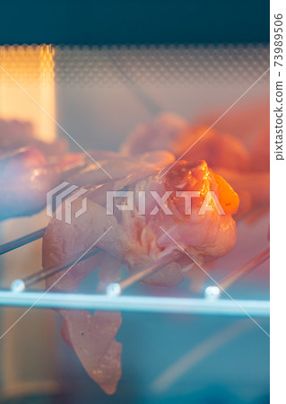 Vertical photo of roasted chicken wings on oven rack 73989506