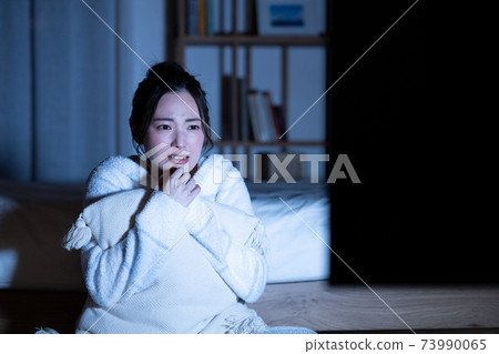 年輕女子看夜間恐怖片 73990065