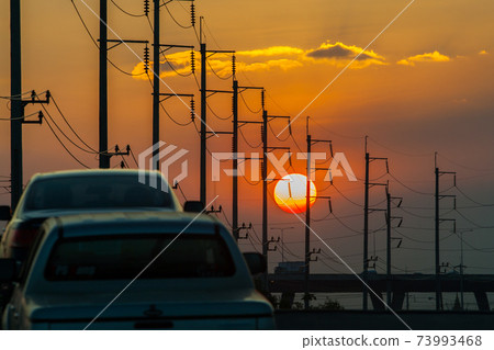 Electricity post in front of sunset background Electricity post in front of sunset background 73993468