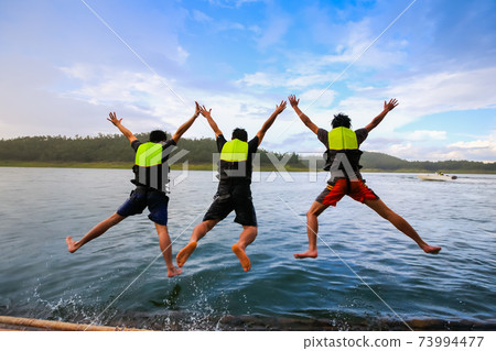 People is jumping to water in dam 73994477