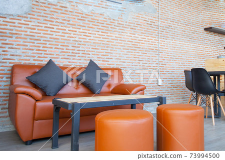 Leather orange sofa with brick wall brown background Leather orange sofa with brick wall brown background 73994500