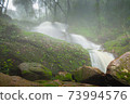 waterfall in forest in rain season 73994576