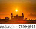 silhouette of a mosque againts colorful sunrise 73994648