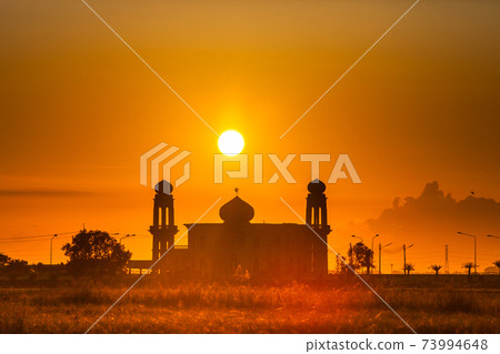 silhouette of a mosque againts colorful sunrise 73994648