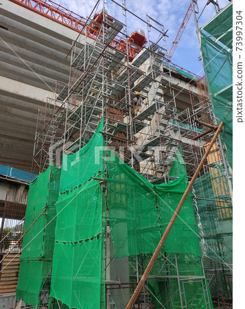 SHAH ALAM, MALAYSIA -AUGUST 8, 2020: Temporary staircase and falsework are used as the temporary support during construction. It is wrapped with safety netting for safety purposes. Installed by worker 73997304