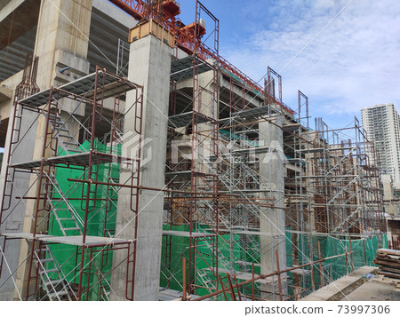 SHAH ALAM, MALAYSIA -AUGUST 8, 2020: Temporary staircase and falsework are used as the temporary support during construction. It is wrapped with safety netting for safety purposes. Installed by worker 73997306