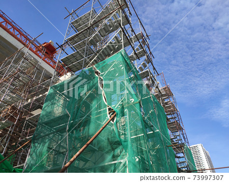 SHAH ALAM, MALAYSIA -AUGUST 8, 2020: Temporary staircase and falsework are used as the temporary support during construction. It is wrapped with safety netting for safety purposes. Installed by worker 73997307