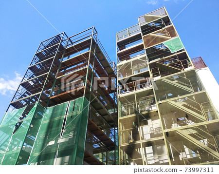 SHAH ALAM, MALAYSIA -AUGUST 8, 2020: Temporary staircase and falsework are used as the temporary support during construction. It is wrapped with safety netting for safety purposes. Installed by worker 73997311
