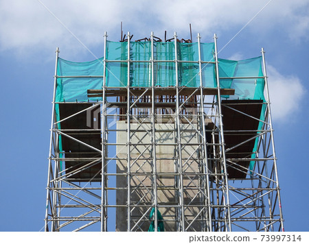 SHAH ALAM, MALAYSIA -AUGUST 8, 2020: Temporary staircase and falsework are used as the temporary support during construction. It is wrapped with safety netting for safety purposes. Installed by worker 73997314