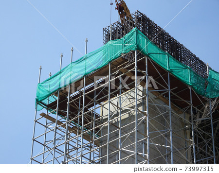 SHAH ALAM, MALAYSIA -AUGUST 8, 2020: Temporary staircase and falsework are used as the temporary support during construction. It is wrapped with safety netting for safety purposes. Installed by worker SHAH ALAM, MALAYSIA -AUGUST 8, 2020: Temporary staircase and falsework are used as the temporary support during construction. It is wrapped with safety netting for safety purposes. Installed by worker 73997315