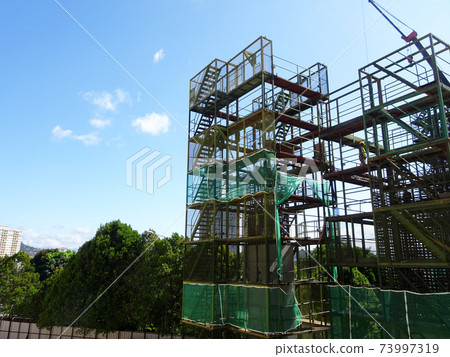 SHAH ALAM, MALAYSIA -AUGUST 8, 2020: Temporary staircase and falsework are used as the temporary support during construction. It is wrapped with safety netting for safety purposes. Installed by worker SHAH ALAM, MALAYSIA -AUGUST 8, 2020: Temporary staircase and falsework are used as the temporary support during construction. It is wrapped with safety netting for safety purposes. Installed by worker 73997319