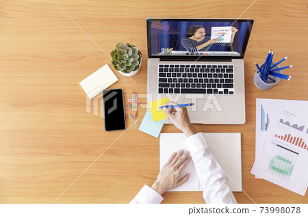 Top view Businessman and businesswoman analysis financial chart with videoconference online meeting. Hand of businesswomen using laptop meeting with diverse colleagues. Covid-19 working from home. Top view Businessman and businesswoman analysis financial chart with videoconference online meeting. Hand of businesswomen using laptop meeting with diverse colleagues. Covid-19 working from home. 73998078