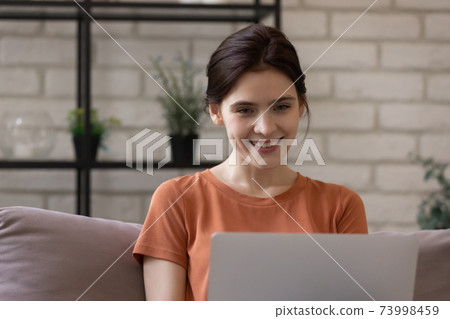 Close up smiling woman using laptop, chatting online at home 73998459
