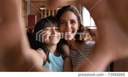 Head shot portrait happy mother and daughter taking selfie Head shot portrait happy mother and daughter taking selfie 73998866