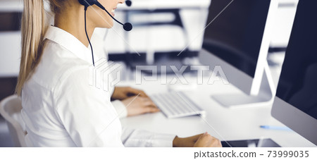 Unknown female customer service representative is consulting clients online using headset.close-up. Call center and business concept 73999035