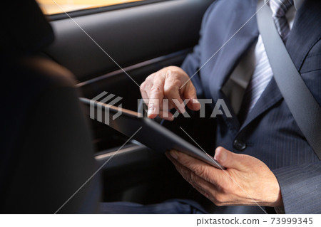 在車內,一位經營平板電腦的商人 在車內,一位經營平板電腦的商人 73999345