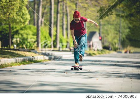 Asian woman skateboarder skateboarding in modern city Asian woman skateboarder skateboarding in modern city 74000908