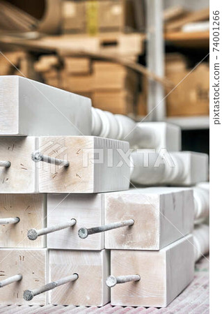White balusters. Balusters process production. Solid wood balusters before finishing. Furniture manufacture. Close-up White balusters. Balusters process production. Solid wood balusters before finishing. Furniture manufacture. Close-up 74001266