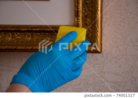 Cleaning with a sponge in a blue rubber glove Cleaning with a sponge in a blue rubber glove 74001327
