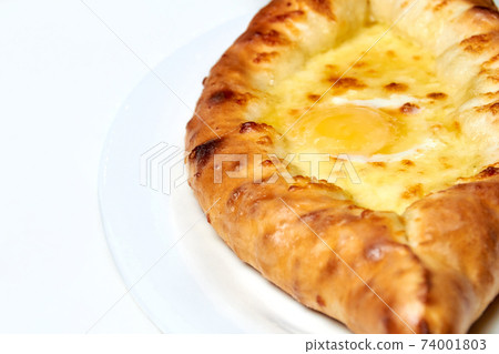 Ajarian traditional flatbread khachapuri or hachapuri with cheese, egg and butter on a plate Ajarian traditional flatbread khachapuri or hachapuri with cheese, egg and butter on a plate 74001803