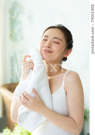 一個美麗的女人,用毛巾擦她的臉 一個美麗的女人,用毛巾擦她的臉 74001908