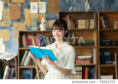 Young woman reading a book 74002255