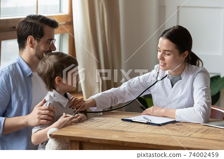 Female pediatrician listen to small child chest 74002459