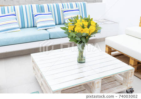 Flowers arrangement on table outdoors on the terrace of the house Flowers arrangement on table outdoors on the terrace of the house 74003002