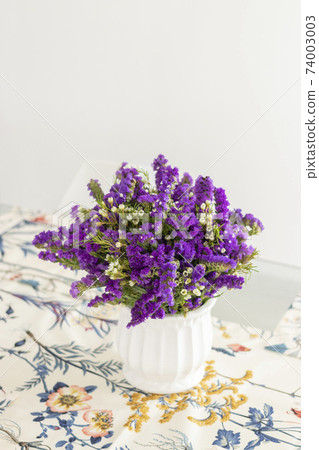 Cute flower arrangement with purple statice, decorating the dinner table Cute flower arrangement with purple statice, decorating the dinner table 74003003