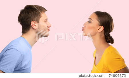 Man and woman reaching to each other trying to kiss 74004873