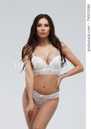 Hot sexy woman in white lace lingerie looking at camera touching body Hot sexy woman in white lace lingerie looking at camera touching body 74005096