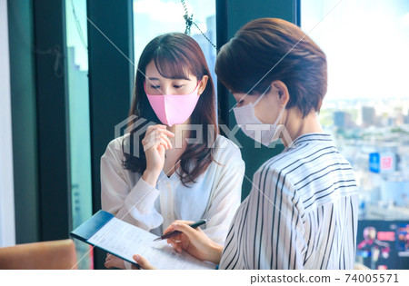 Young business woman in a mask meeting in a shared office Young business woman in a mask meeting in a shared office 74005571