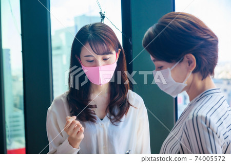 面具會議的一個年輕女商人在一個共享辦公室 面具會議的一個年輕女商人在一個共享辦公室 74005572