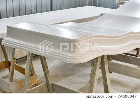 Classic wardrobe crown molding. Production of wood furniture. Furniture manufacture. Close-up 74006047