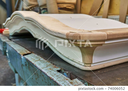 Classic wardrobe crown molding. Production of wood furniture. Furniture manufacture. Close-up Classic wardrobe crown molding. Production of wood furniture. Furniture manufacture. Close-up 74006052