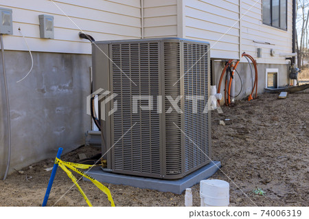 Air conditioning technician to install new air conditioner refueling the air conditioner with freon Air conditioning technician to install new air conditioner refueling the air conditioner with freon 74006319