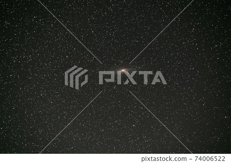 Black night stars covered sky with bright Andromeda galaxy in the middle. 74006522